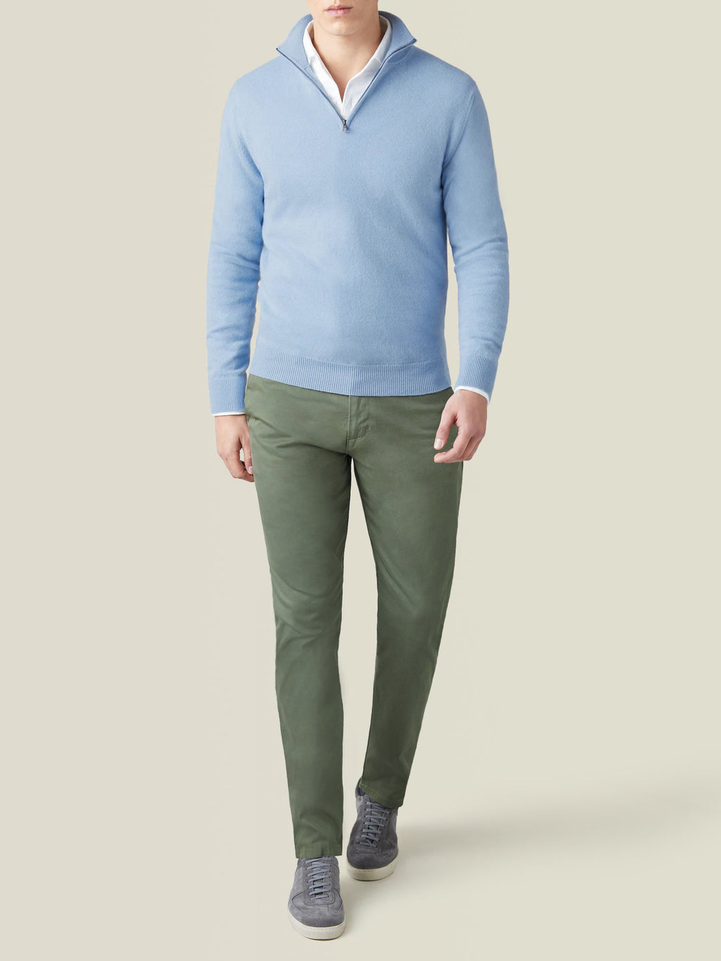 Model wears the Luca Faloni Sky Blue Cashmere Zip-up, styled with green trousers and grey trainers.