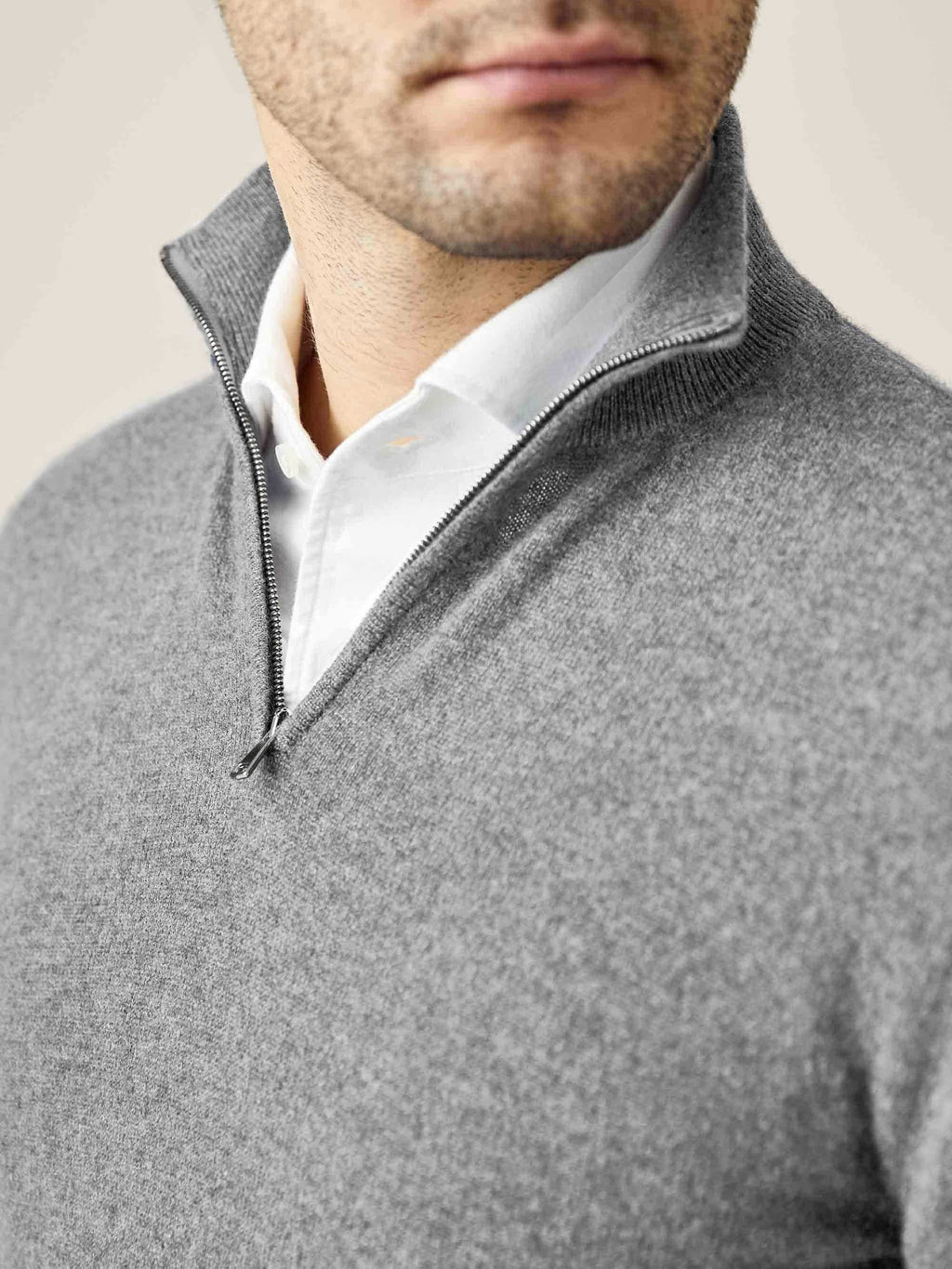Close-up of a man wearing the Dolomiti Grey cashmere zip-up, layered over a white shirt, showing the funnel collar.