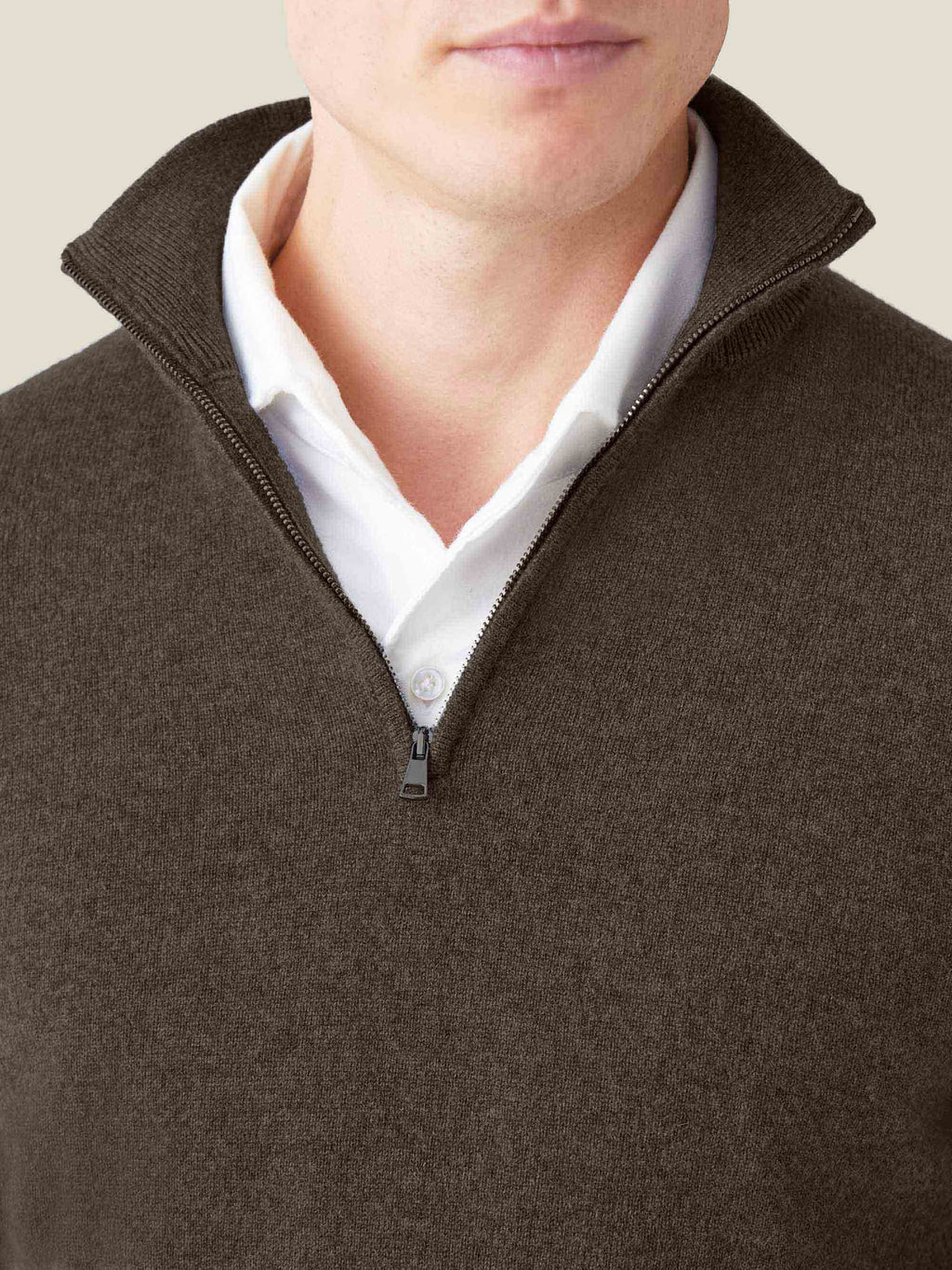 Close-up of a man wearing the chocolate brown cashmere zip-up jumper layered over a white collared shirt.