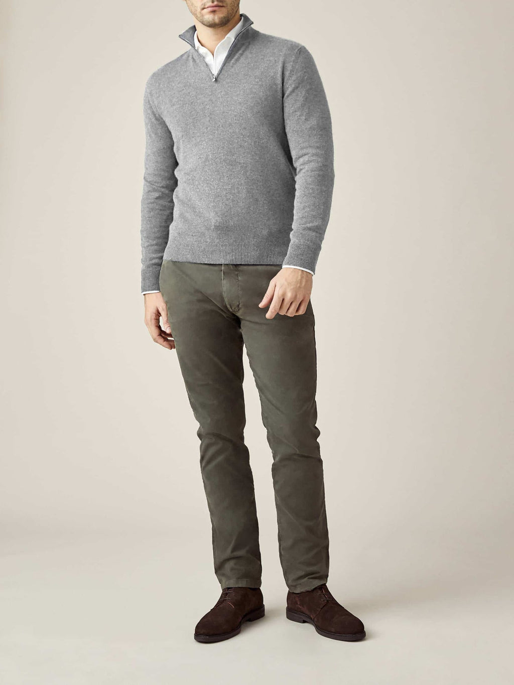 Model wears the Dolomiti Grey Cashmere Zip-up by Luca Faloni, styled over a white shirt with olive green trousers.