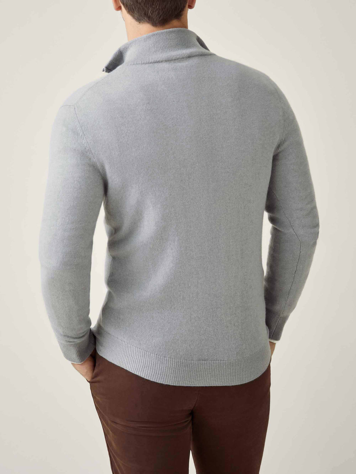 Model showcasing the back view of the Misty Grey Cashmere Zip-up, highlighting its classic fit and soft texture.