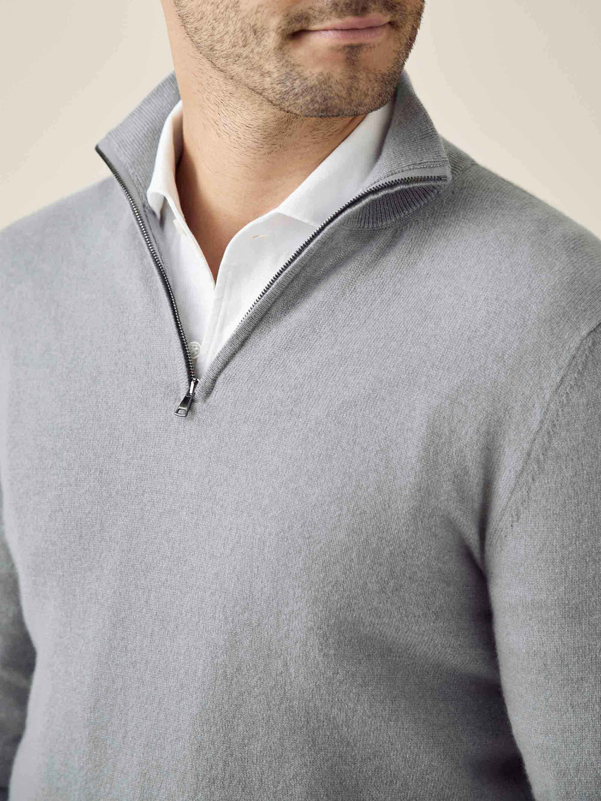 Close-up of a man wearing the Luca Faloni cashmere zip-up in misty grey, highlighting the ribbed collar and zipper detail.