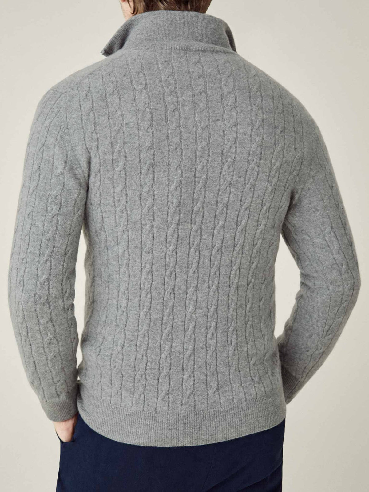 Back view of a model wearing the Dolomiti Grey Cashmere Cable Knit Zip-up, showcasing its detailed texture.
