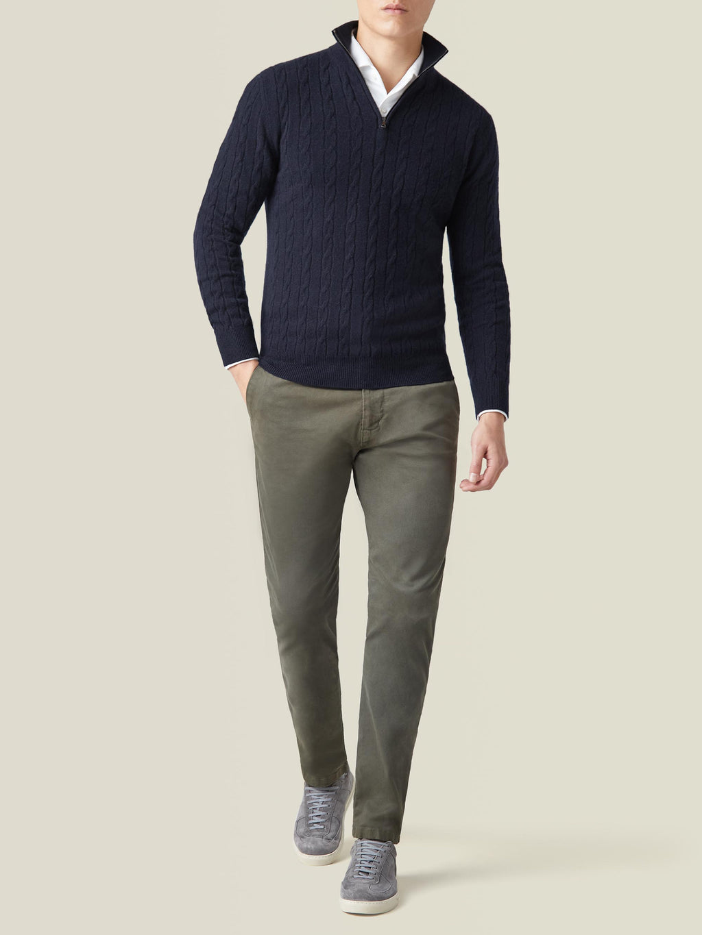 Model wearing the Midnight Blue Cashmere Cable Knit Zip-up with a white shirt, olive trousers, and grey sneakers.