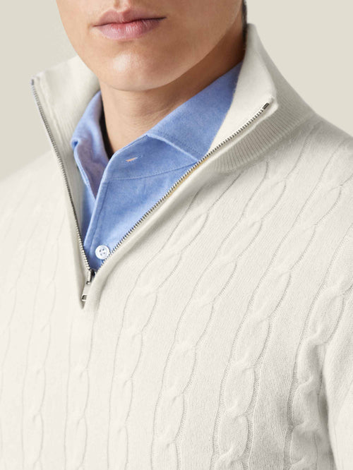 Close-up of a man wearing the ivory cashmere cable knit zip-up, highlighting the funnel collar and textured knit.