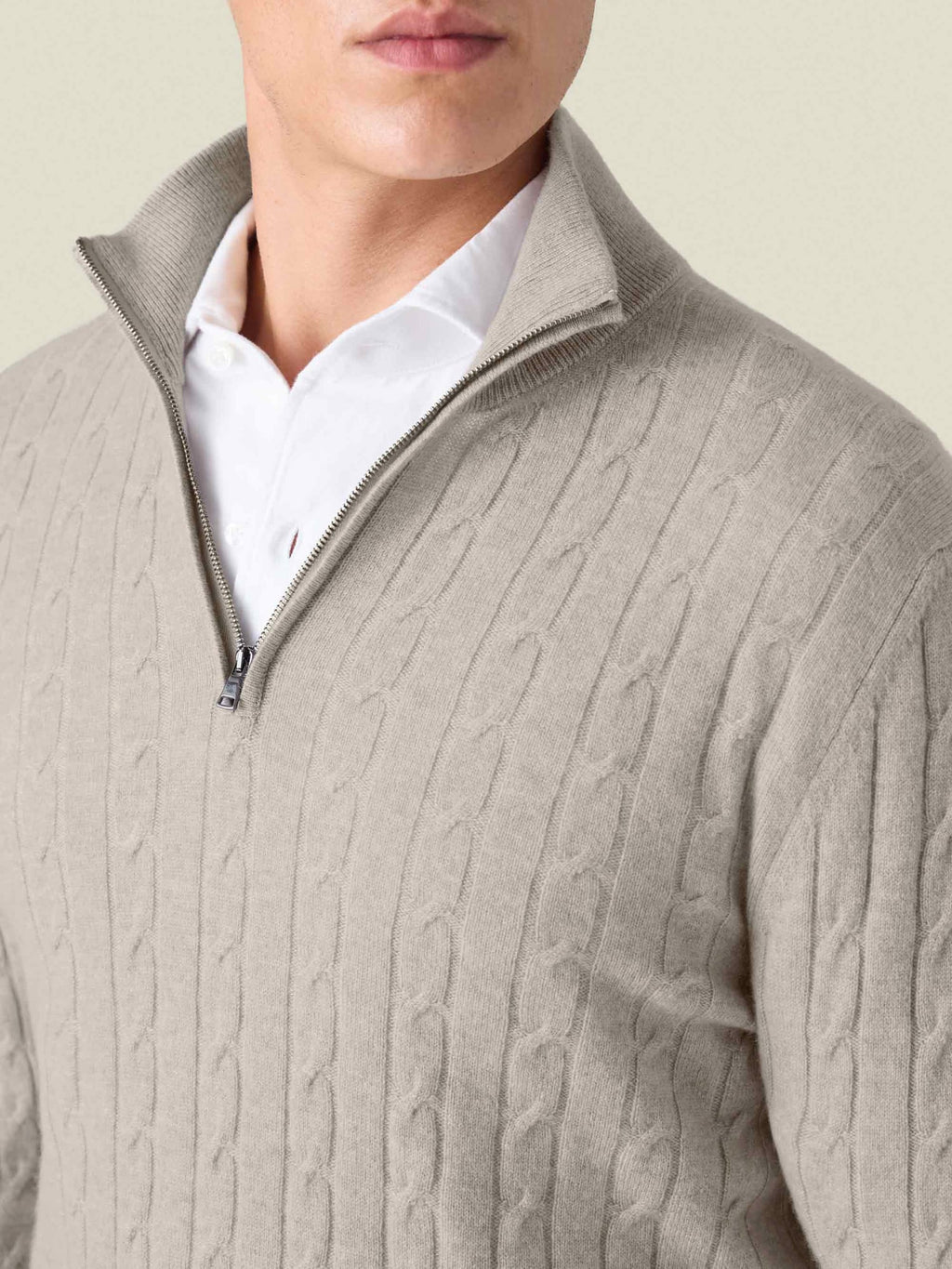 Detailed shot of the Luca Faloni Cable Knit Zip-up in almond, worn by a model over a white shirt.