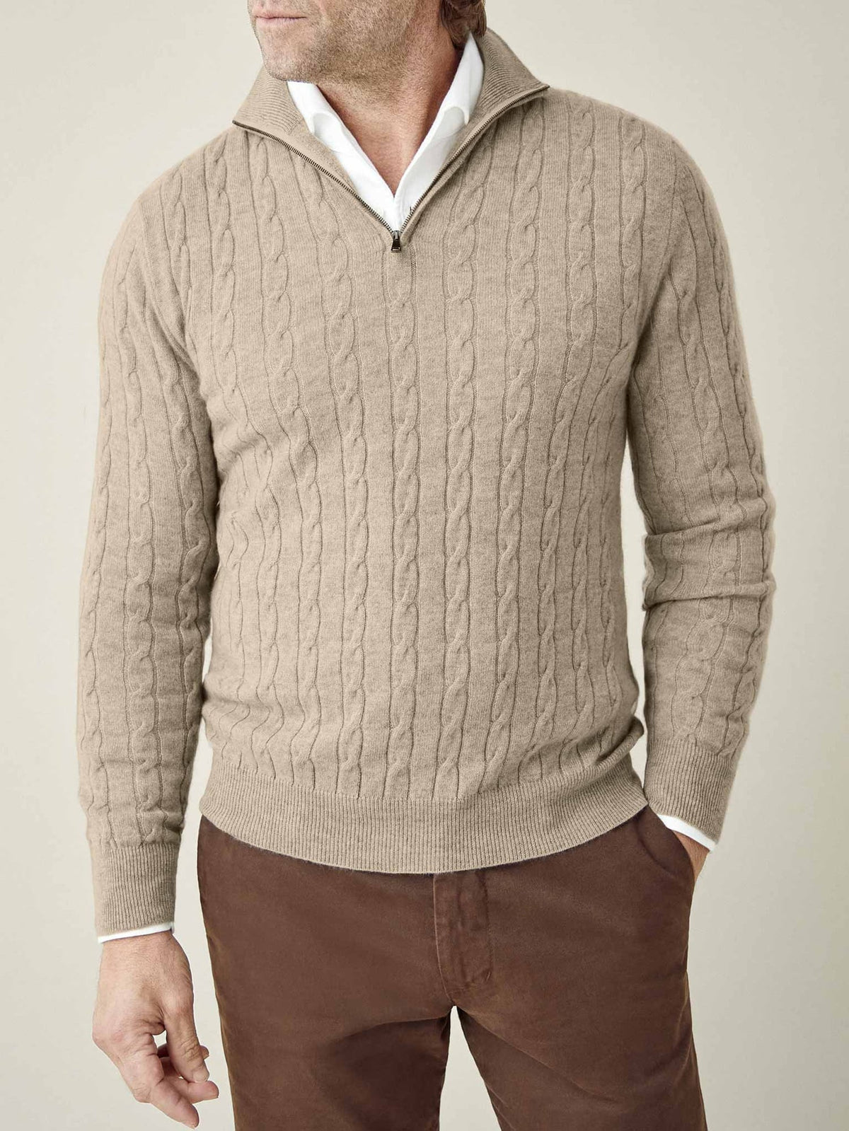 Front view of a model wearing the Cable Knit Zip-up in Camel Beige, layered over a white collared shirt.