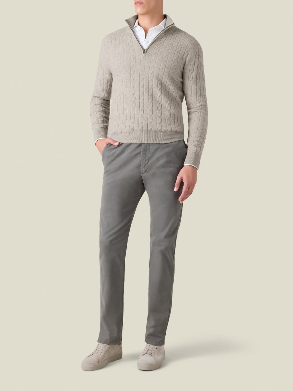 Front view of a model wearing the Luca Faloni Cable Knit Zip-up in almond, styled with grey trousers.