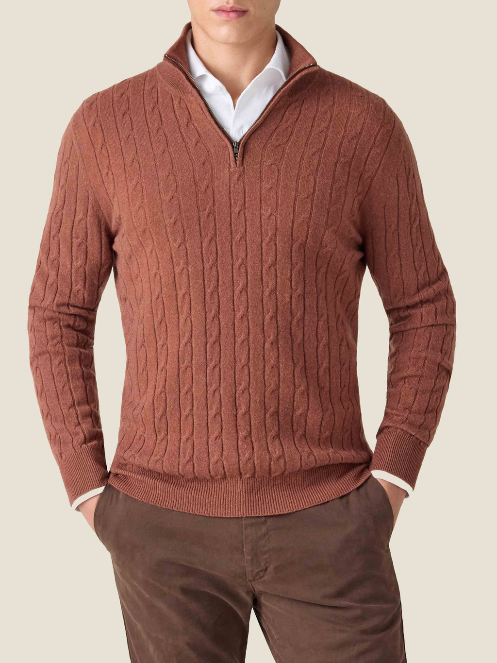 Model wearing Luca Faloni's Rust Cashmere Cable Knit Zip-up layered over a white shirt and brown trousers.