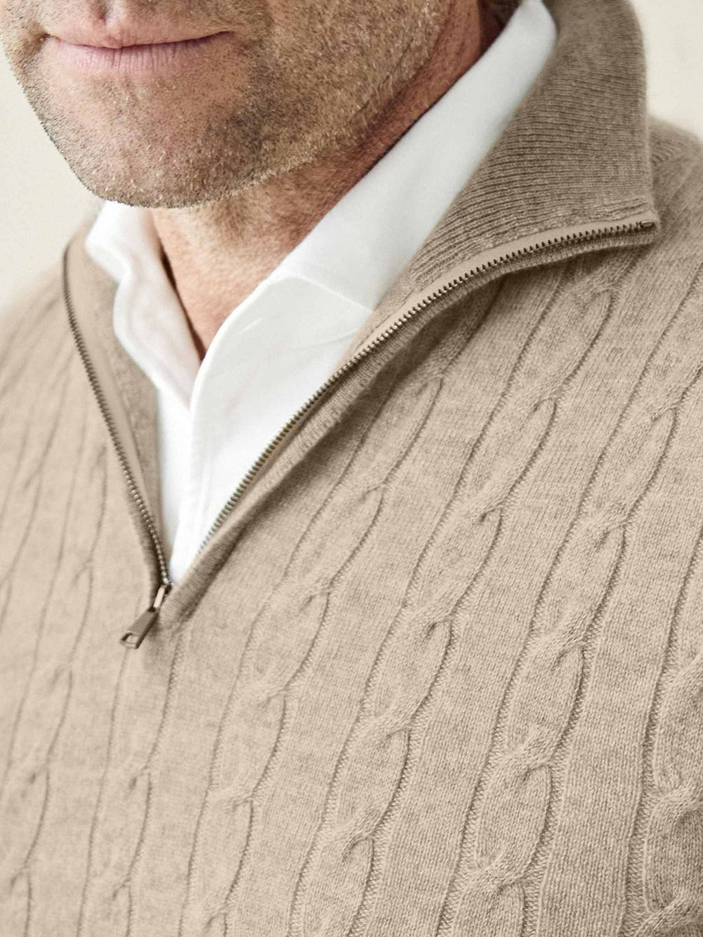 A close-up view of a man wearing the Camel Beige Cable Knit Zip-up, highlighting the soft cashmere texture and zip detail.