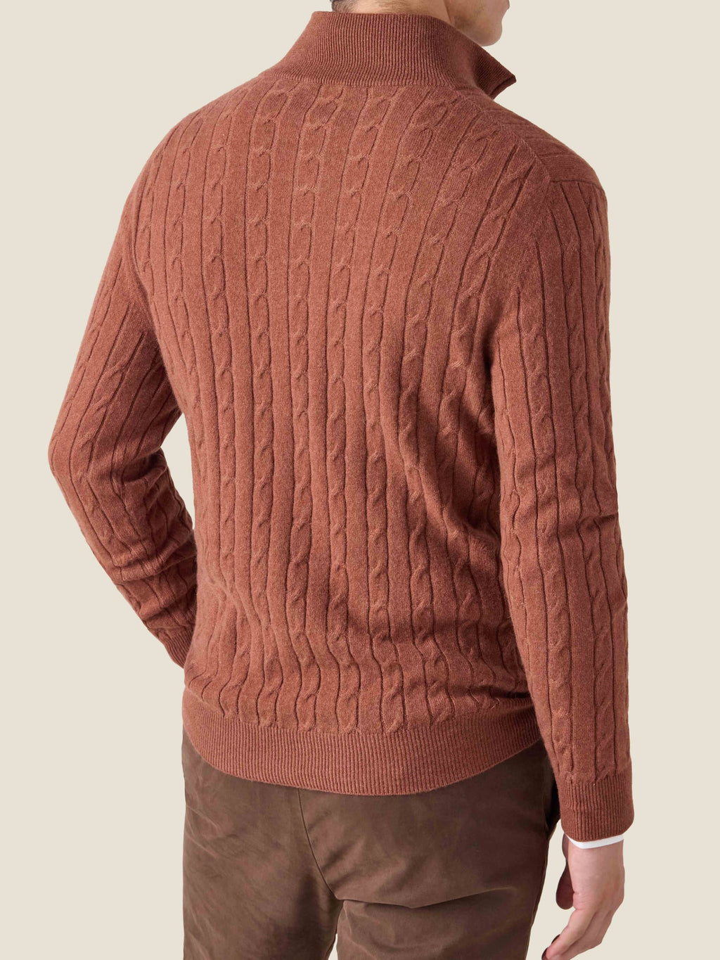 Back view of a man wearing a rust cashmere Cable Knit Zip-up, showing the detailed cable knit texture.