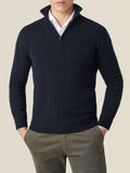 Front view of a model wearing a midnight blue cashmere cable knit zip-up sweater over a white shirt and olive trousers.