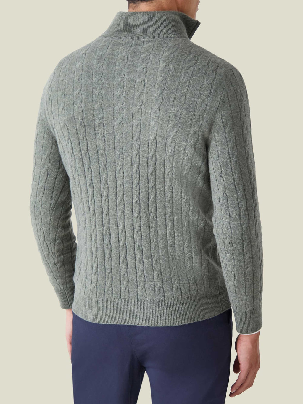 Back view of a model wearing the Moss Green Cashmere Cable Knit Zip-up, showing the detailed texture and fit.