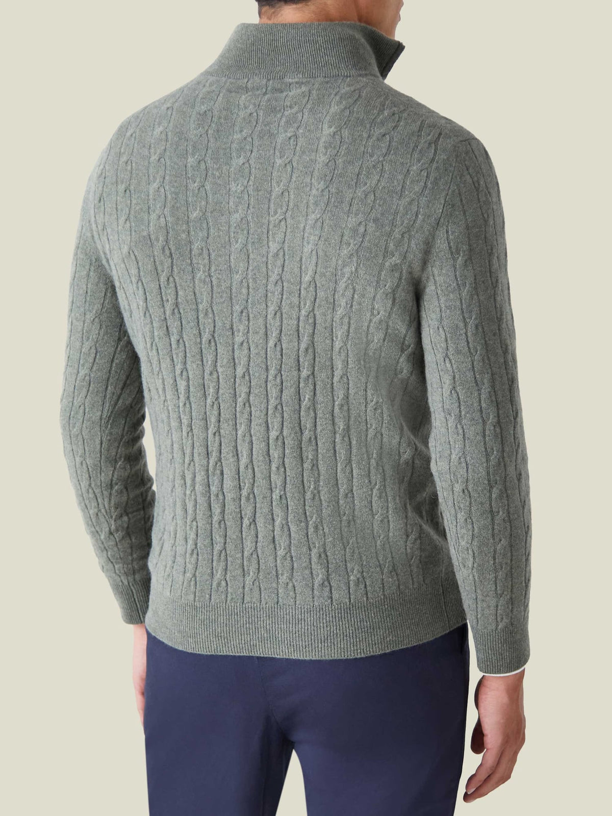Back view of a model wearing the Moss Green Cashmere Cable Knit Zip-up, showing the detailed texture and fit.