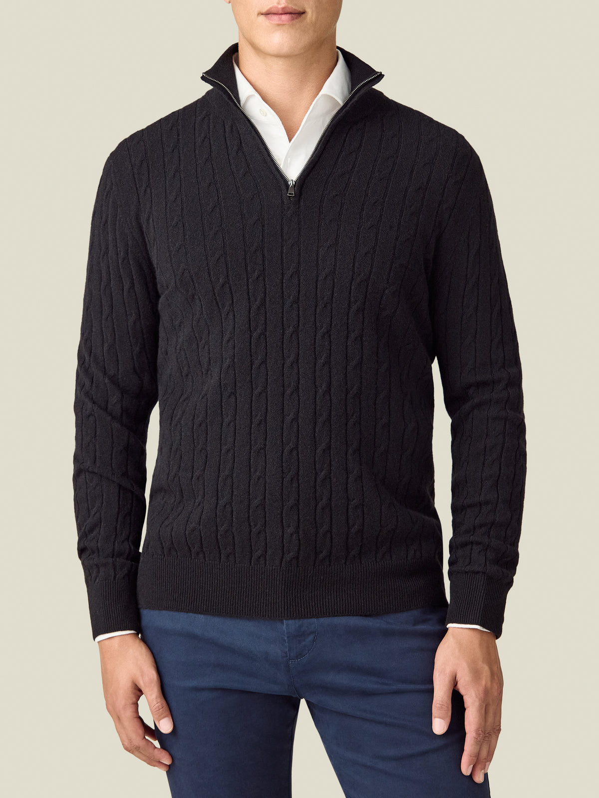 Front view of a model wearing the Luca Faloni Cable Knit Zip-up in black, layered over a white shirt.