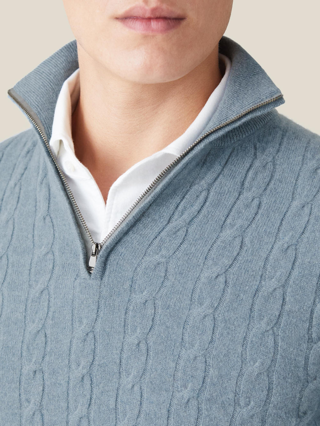 Close-up detail of the funnel neck and zip on the French Blue Cashmere Cable Knit Zip-up, layered over a white shirt.