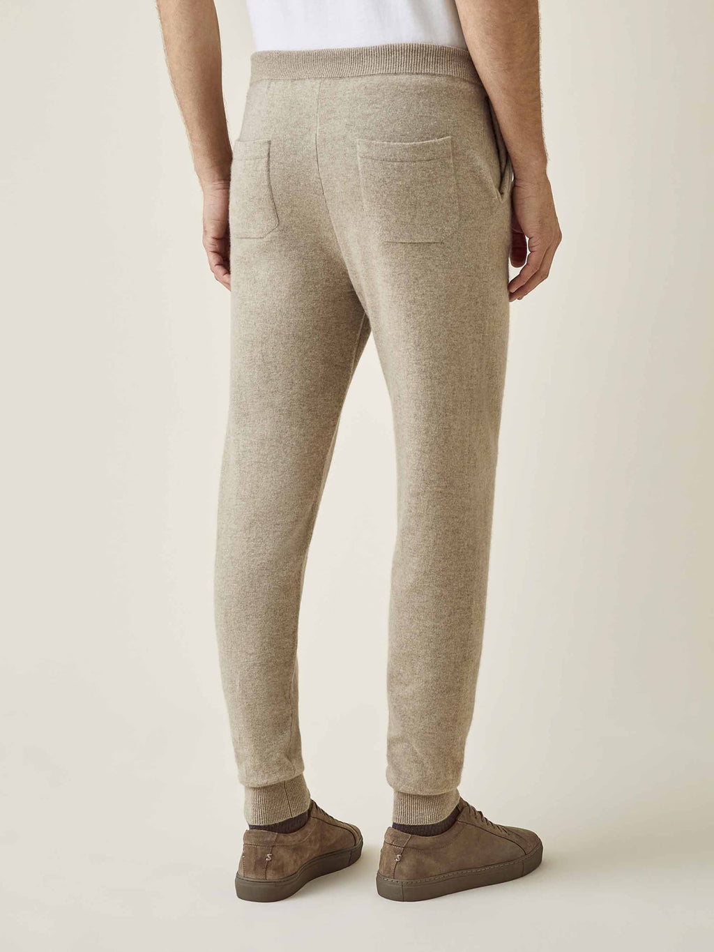 Back view of a model wearing Luca Faloni's Camel Beige Cashmere Joggers, showcasing the fit and back pockets.