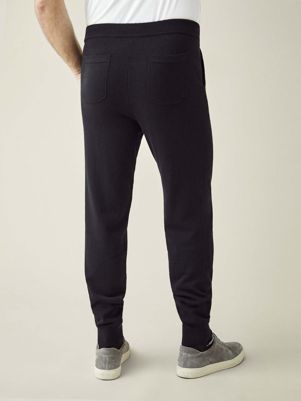 A back view of a model wearing the Black Cashmere Joggers, showcasing the tapered fit and back pockets.