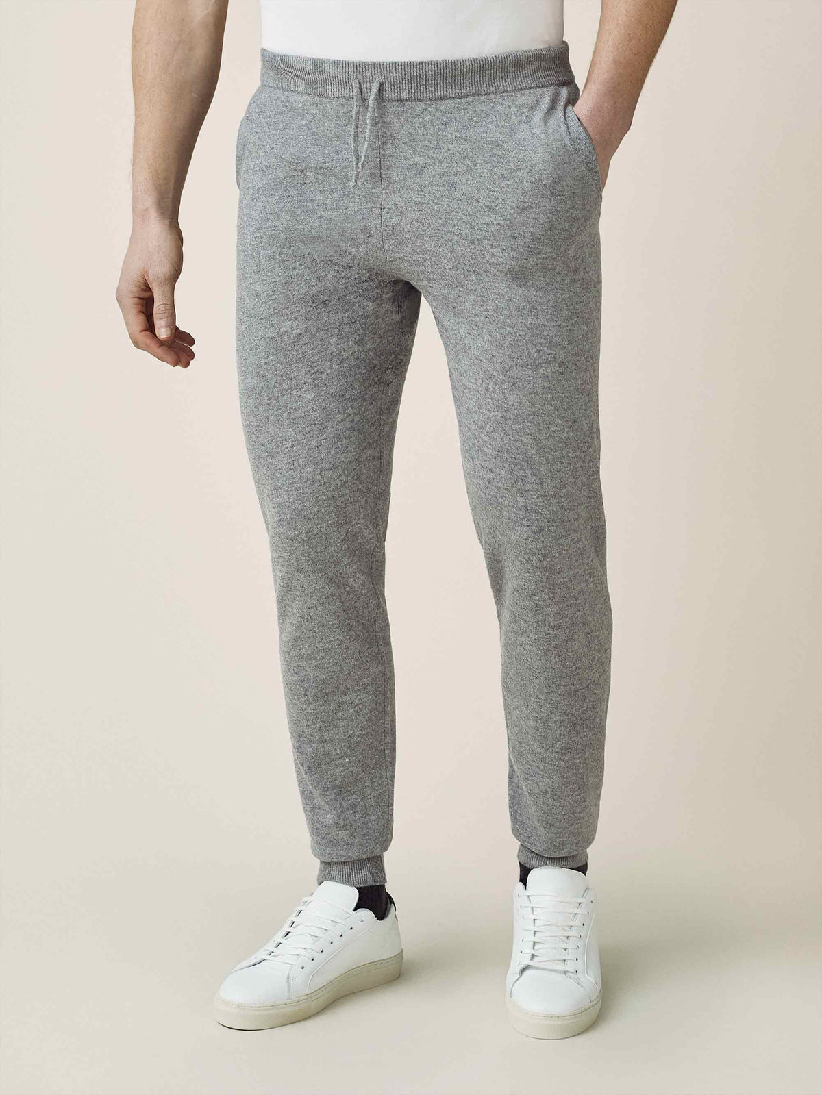 Front view of a man wearing Luca Faloni's Dolomiti Grey cashmere joggers with a white t-shirt and white sneakers.