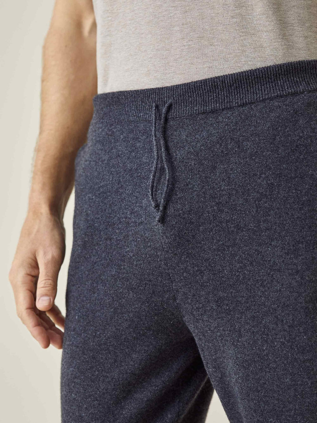 A close-up of the Luca Faloni charcoal grey cashmere joggers, highlighting the ribbed waistband and drawstring detail.