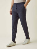 Side profile of a model wearing Luca Faloni's tapered charcoal grey cashmere joggers, styled with white sneakers.