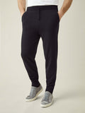 A front view of a model wearing Luca Faloni's tapered fit Black Cashmere Joggers with grey suede trainers.