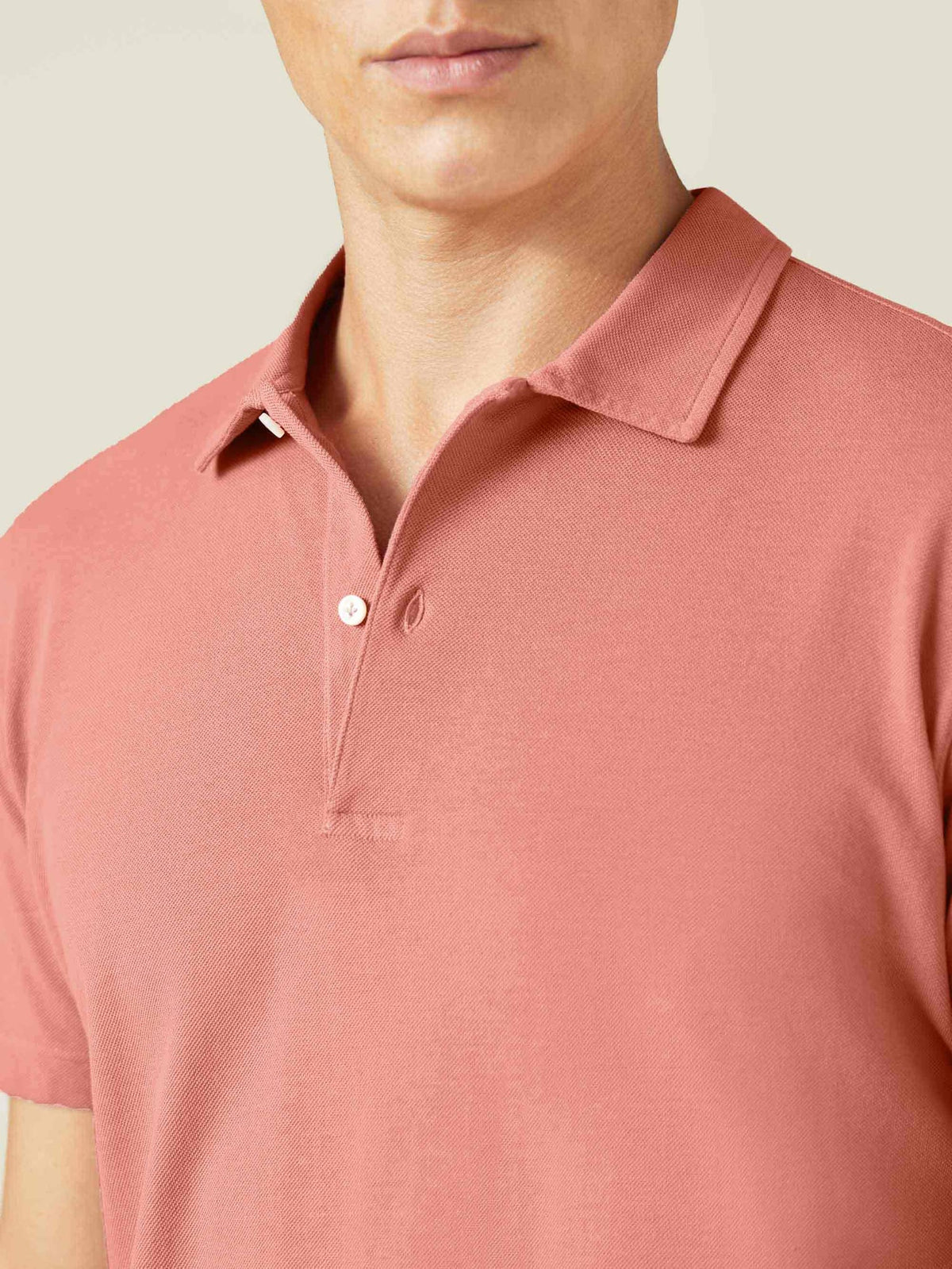 Close-up of a model wearing the Luca Faloni Peach Cotton Piqué Polo, showing the collar and two-button placket.