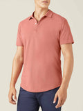 Front view of a model wearing the Luca Faloni short-sleeved Classic Piqué Polo in peach with navy trousers.