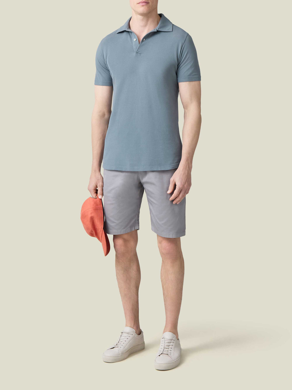A full-length view of a model wearing the Luca Faloni Classic Piqué Polo in French Blue, styled with light grey shorts.