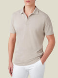 Front view of a man wearing Luca Faloni's oatmeal cotton piqué polo shirt with white trousers.