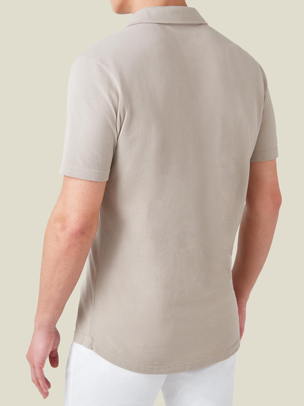 Rear view of a model wearing the Luca Faloni Classic Piqué Polo in oatmeal, showing the classic fit and rounded hem.