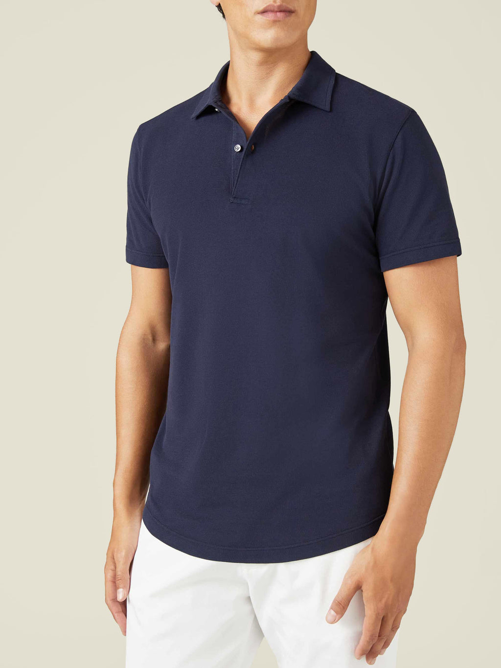 Front view of a model wearing the Luca Faloni Classic Piqué Polo in navy blue with white trousers.