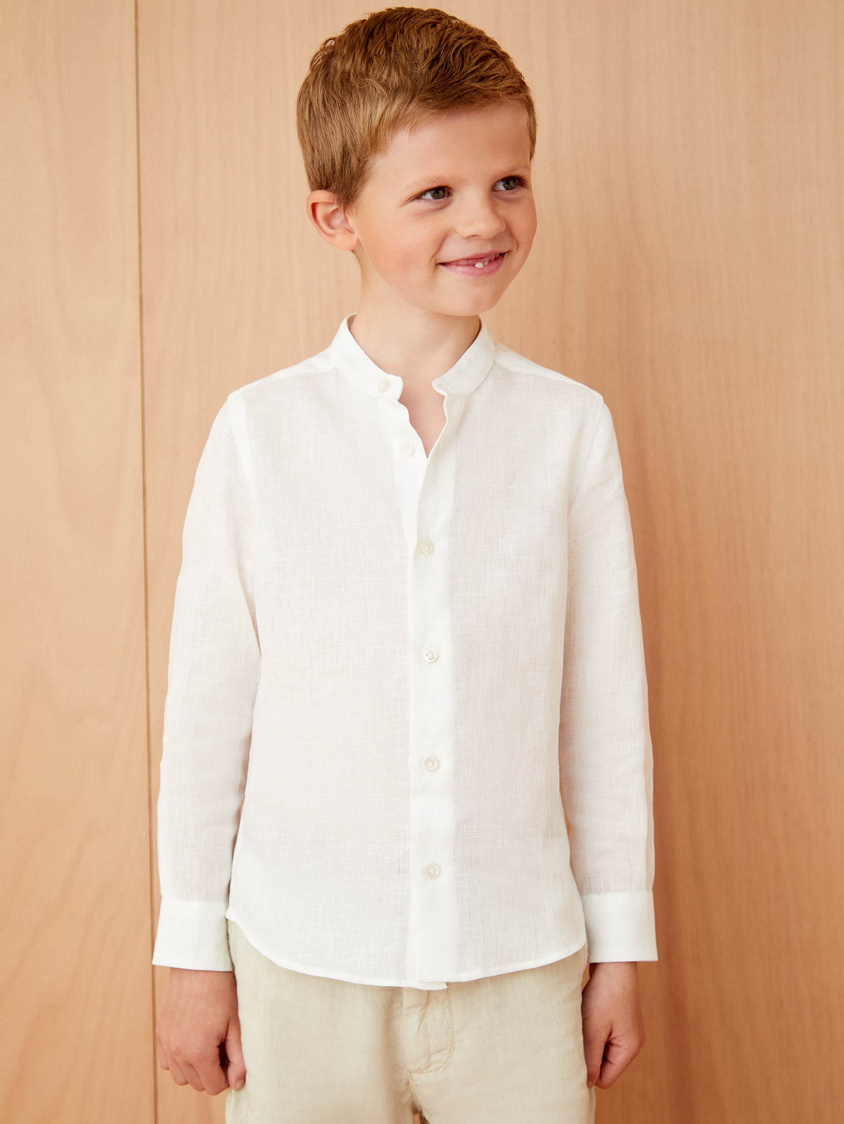 Front view of a young boy wearing the white Luca Faloni Versilia Junior Linen Shirt.
