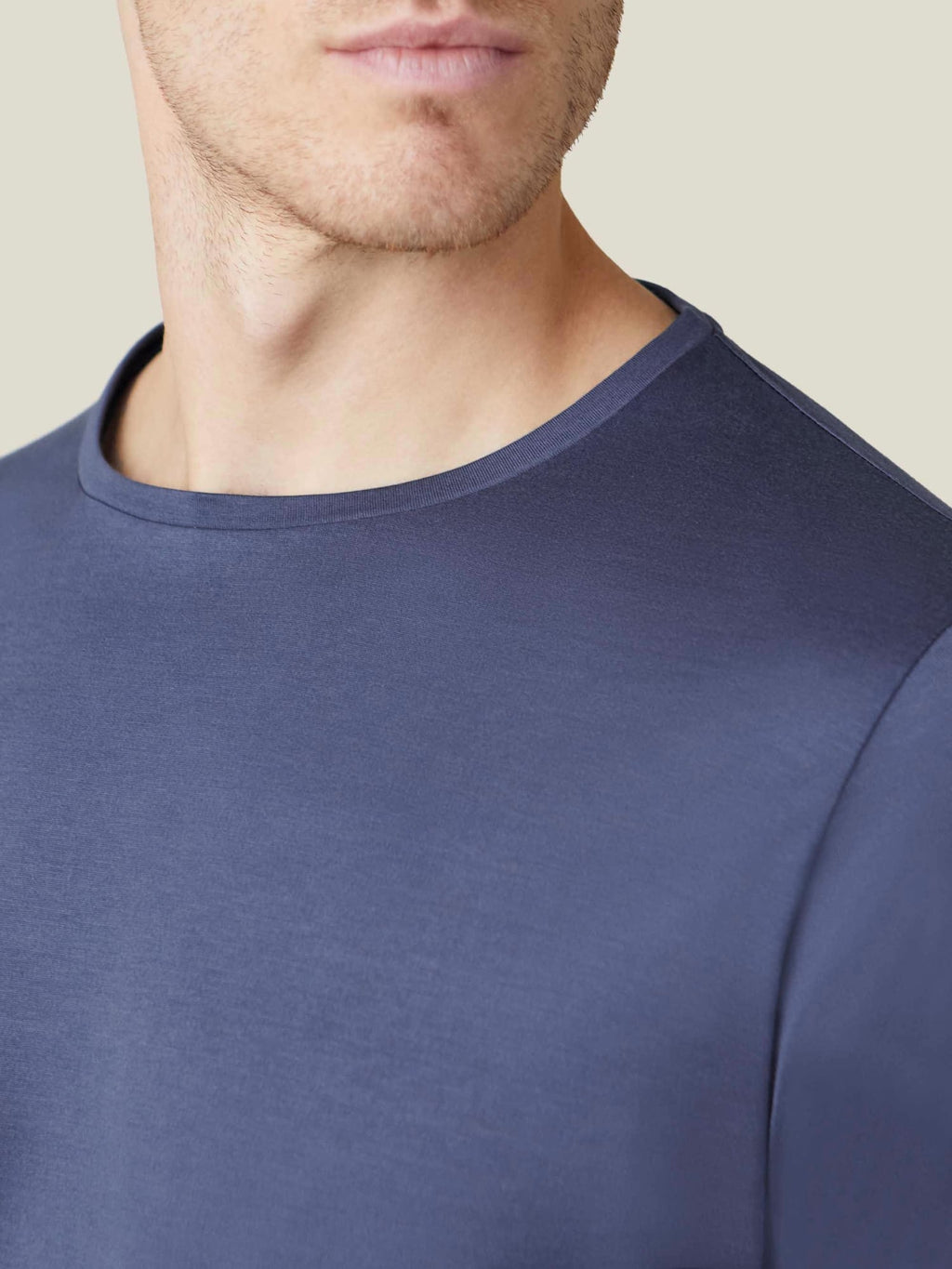 Close-up of a man wearing the Ocean Blue Silk-Cotton Long-Sleeved T-Shirt, detailing the crew neckline and soft fabric.
