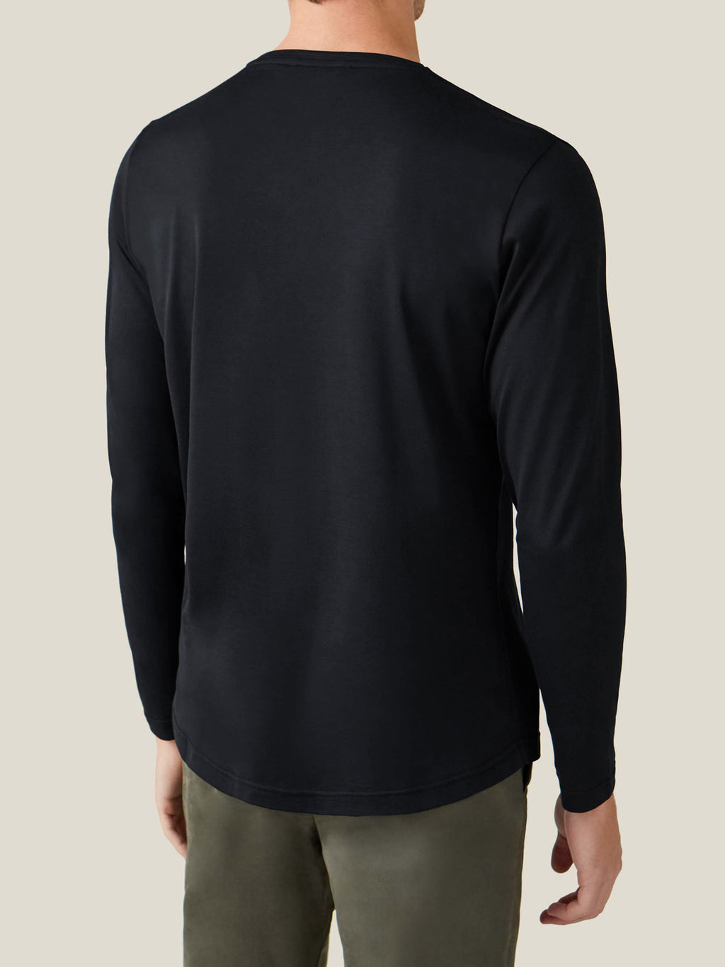 Rear view of a man wearing Luca Faloni's black silk-cotton long-sleeved T-shirt, highlighting the fit and curved hem.