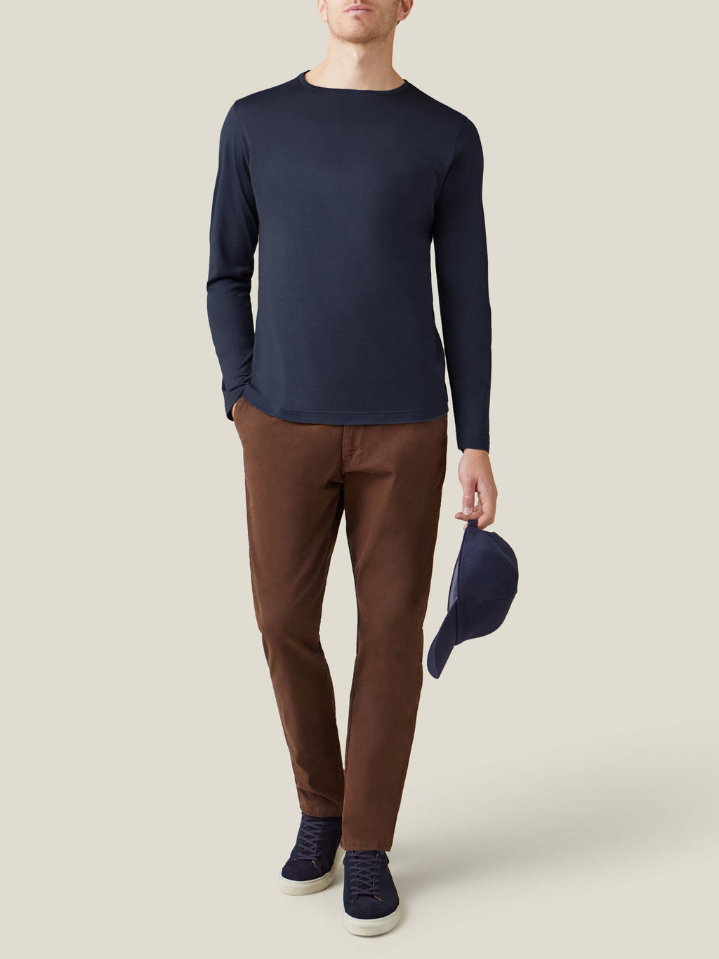 A model wears the Luca Faloni Silk-Cotton Long-Sleeved T-Shirt in Midnight Blue with brown trousers and navy sneakers.