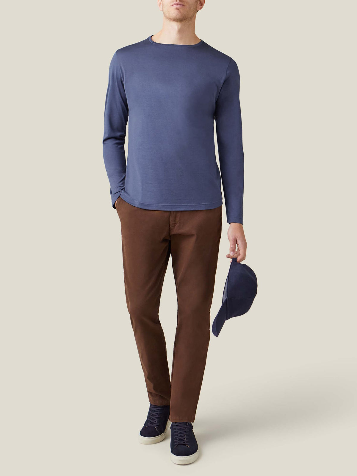 Man wearing the Luca Faloni Ocean Blue Long-Sleeved Silk-Cotton T-Shirt, styled with brown trousers and navy trainers.