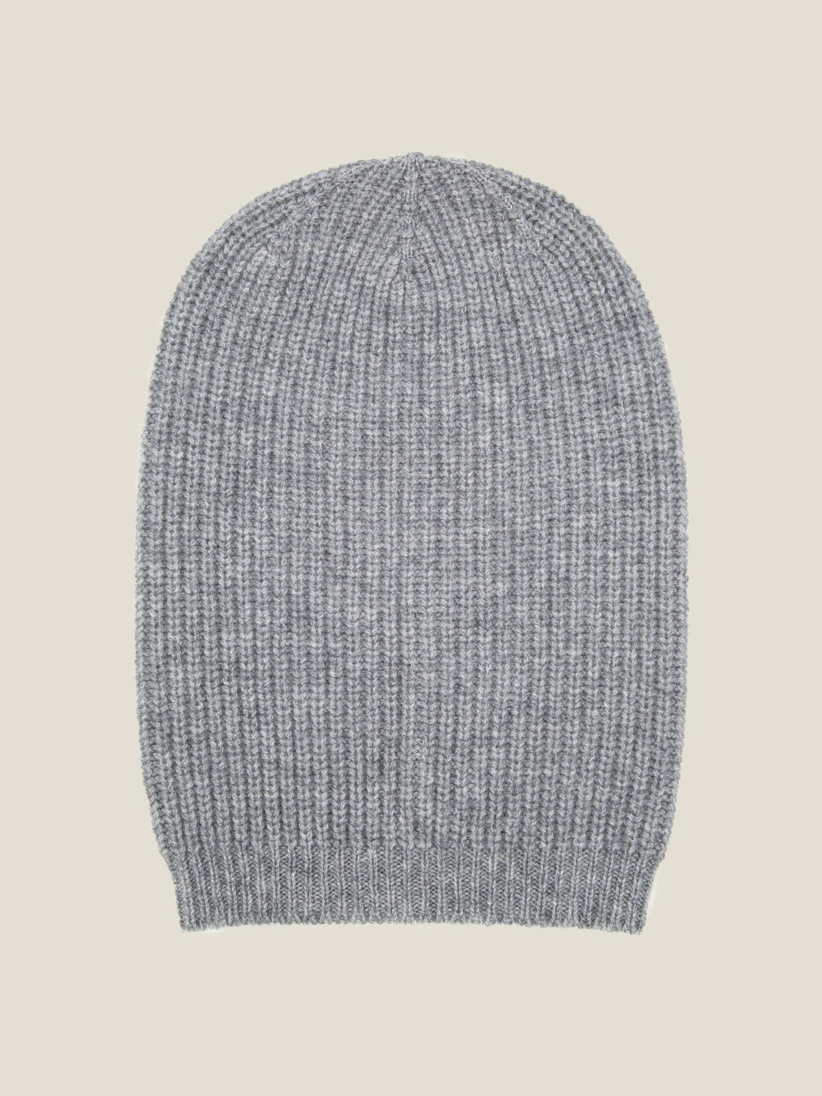 A light grey chunky knit cashmere beanie with a ribbed texture, laid flat against a neutral background.