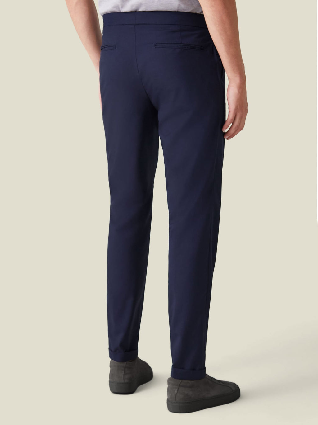 Back view of a model wearing the Navy Blue Lightweight Wool Trousers, showcasing the slim, tapered fit and cuffed hems.