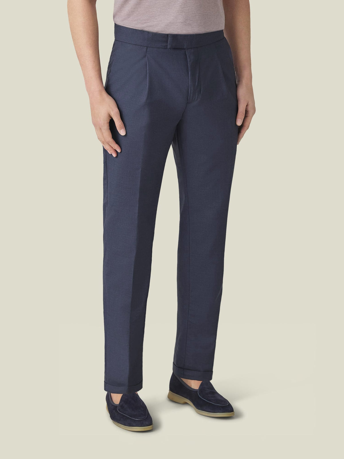 Front view of a model wearing Classic Blue Lightweight Wool Pleated Trousers, showcasing the tapered fit and cuffed hem.