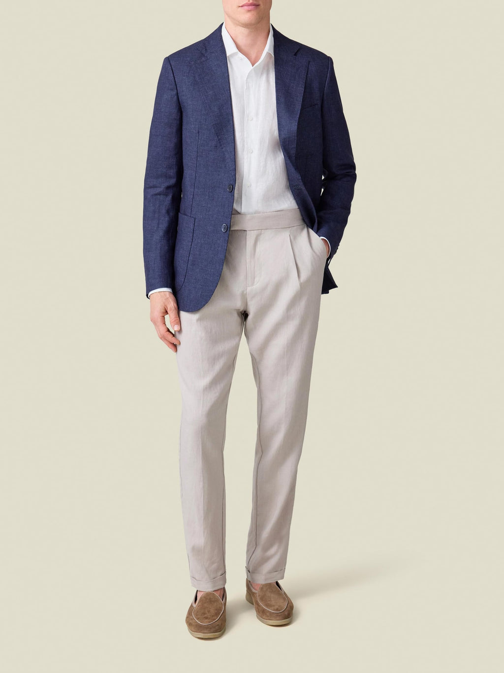 Model wears the white Portofino Linen Shirt under a navy blazer with light grey pleated trousers and suede loafers.