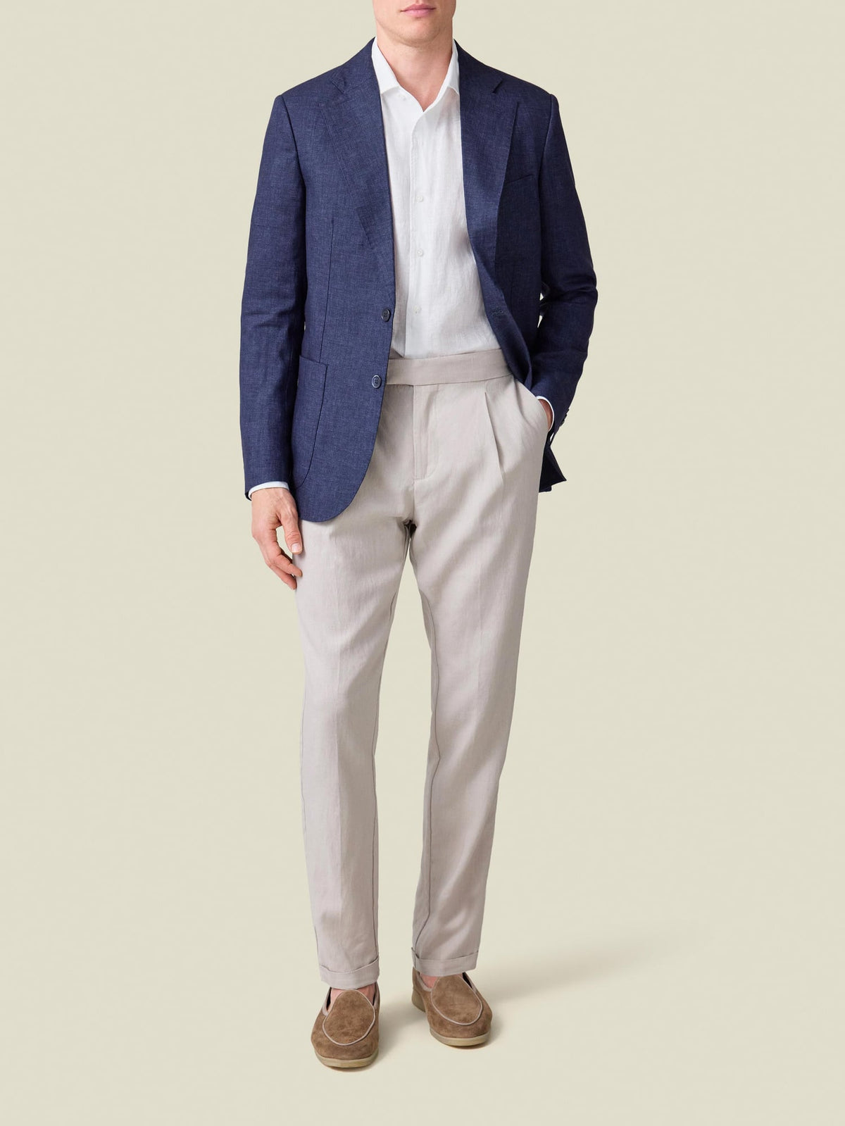 Model wears the white Portofino Linen Shirt under a navy blazer with light grey pleated trousers and suede loafers.