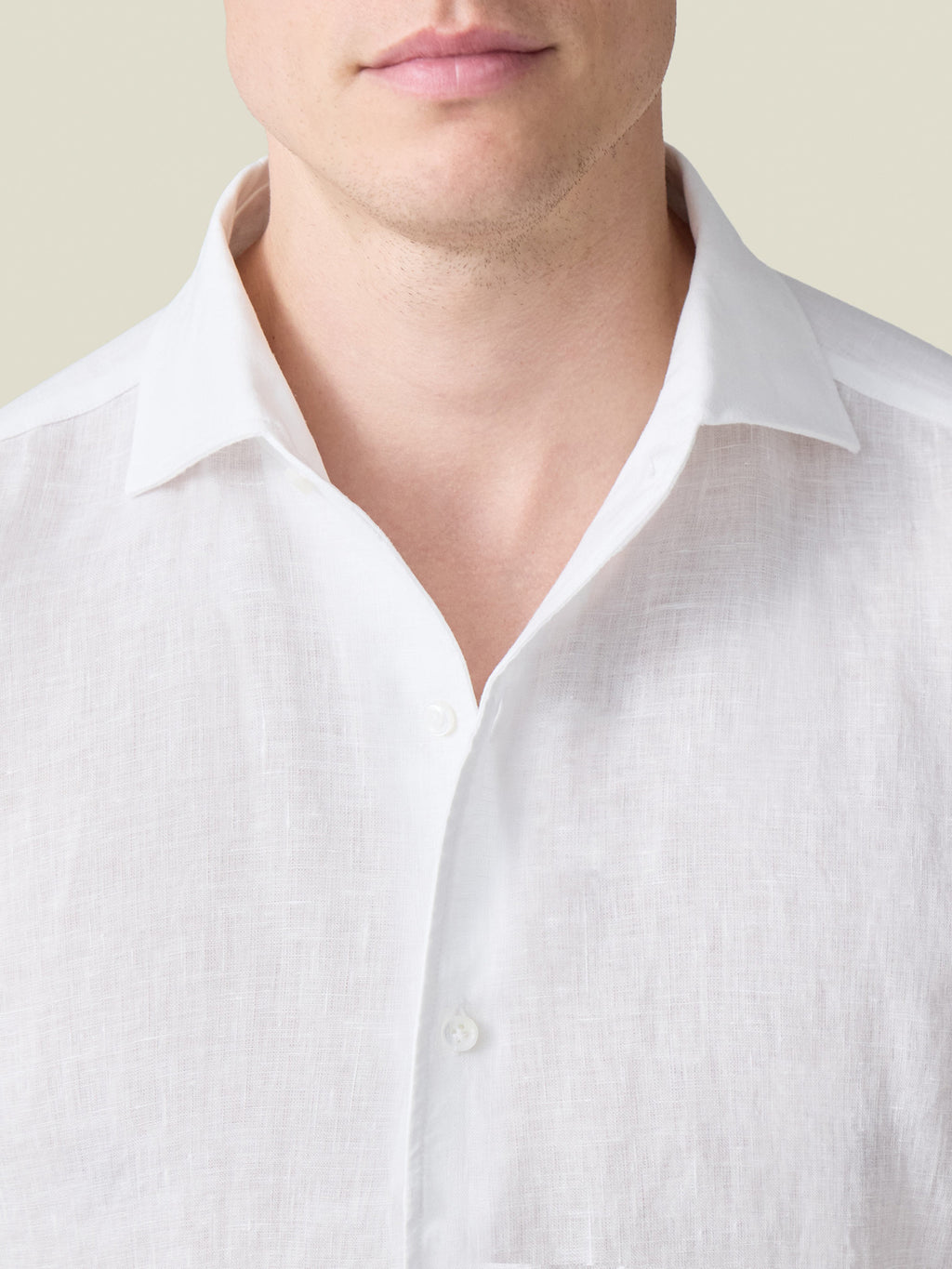 Close-up of a model wearing the white Portofino Linen Shirt, showing the one-piece Paramontura collar and fine texture.