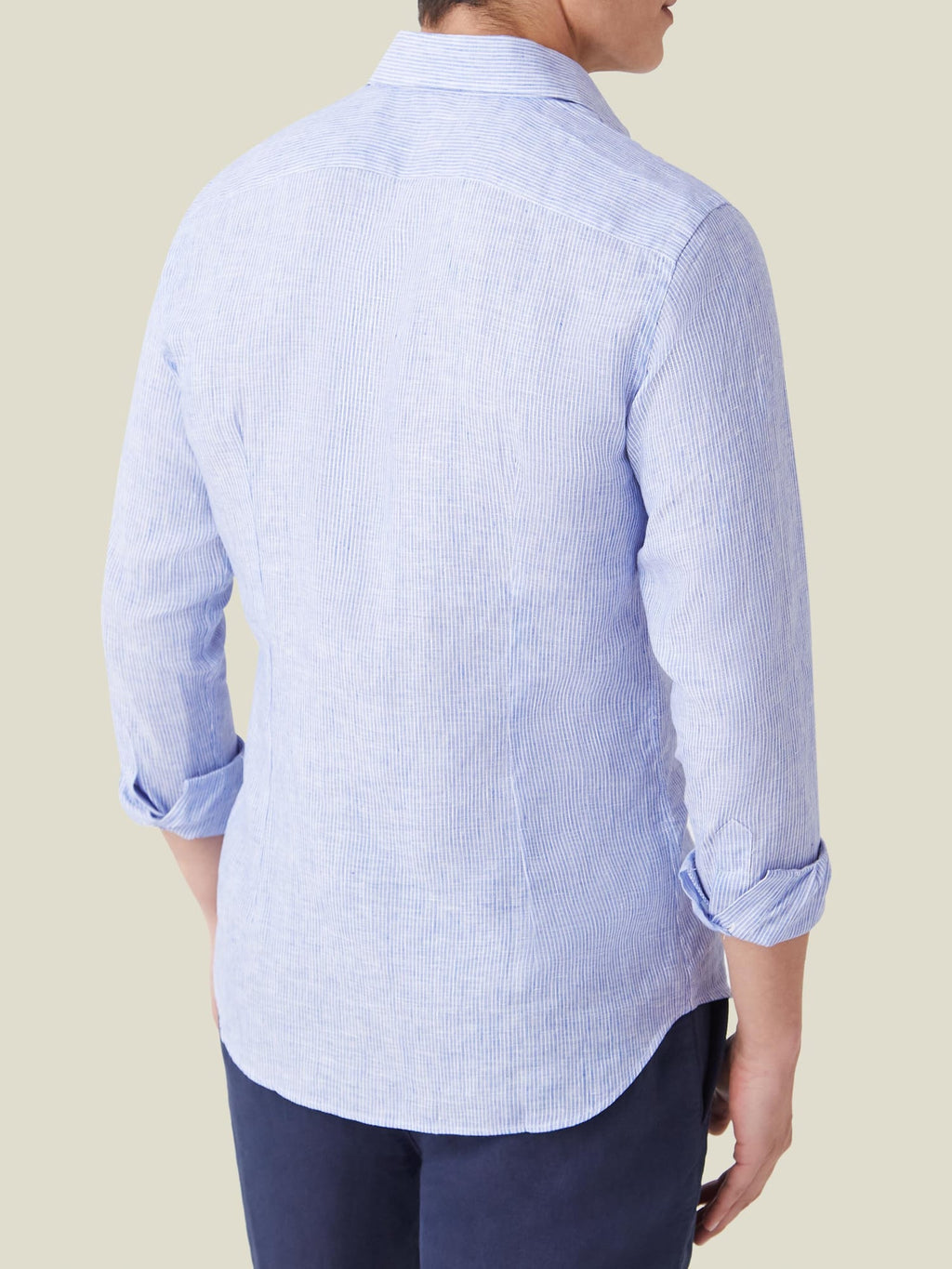 Back of a model wearing the Striped Classic Blue Portofino Linen Shirt, showing its tailored fit and rolled-up sleeves.