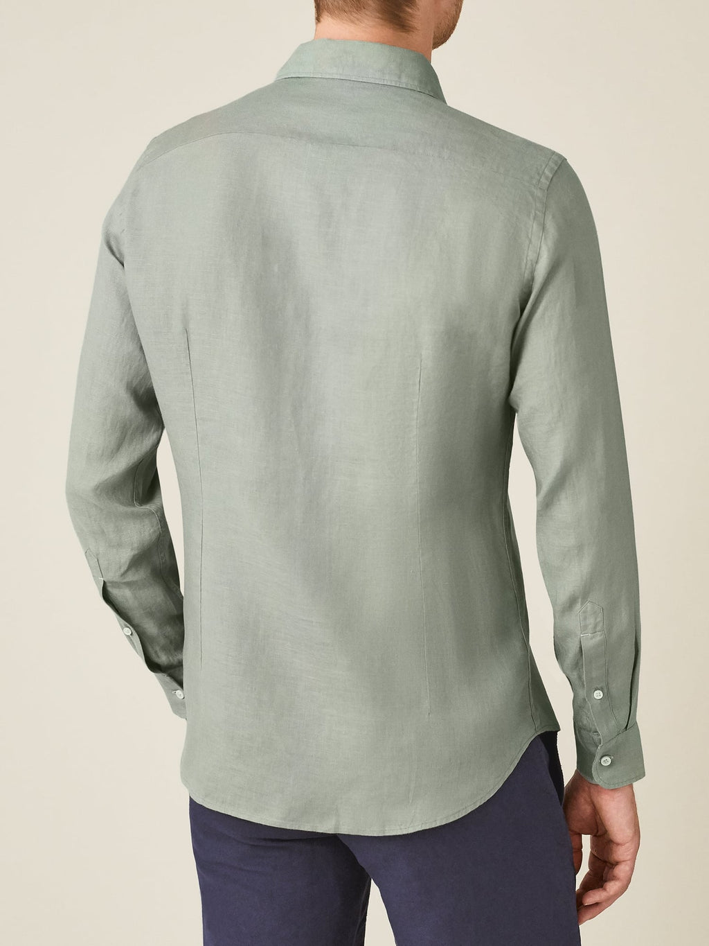 Rear view of a model wearing the tailored Portofino Linen Shirt in sage green.