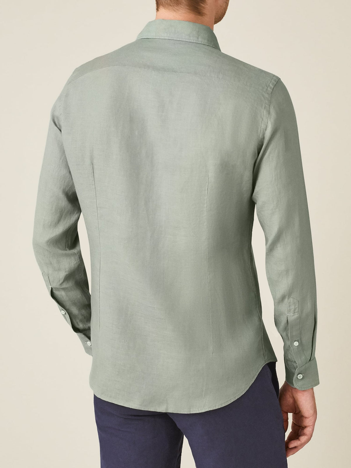 Rear view of a model wearing the tailored Portofino Linen Shirt in sage green.