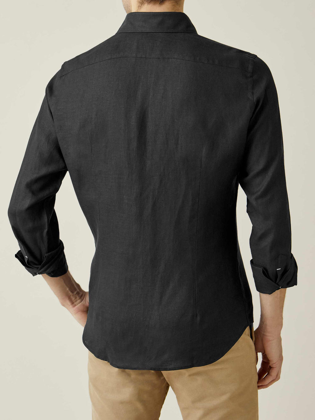 Back view of a model wearing the Black Portofino Linen Shirt, showcasing the tailored fit and curved hem.