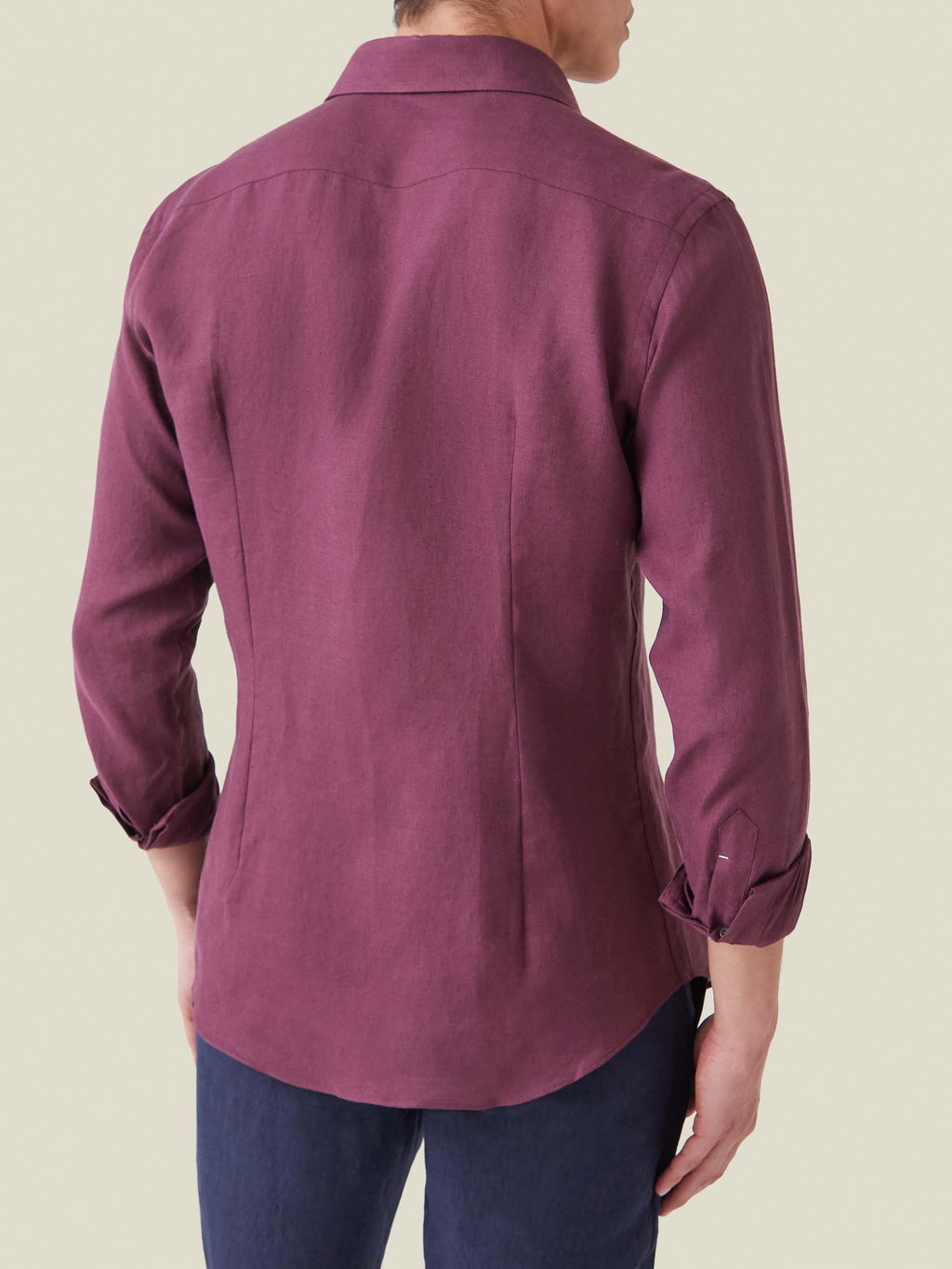 Back view of a model wearing the burgundy Portofino Linen Shirt, showing its tailored fit and rounded hem.
