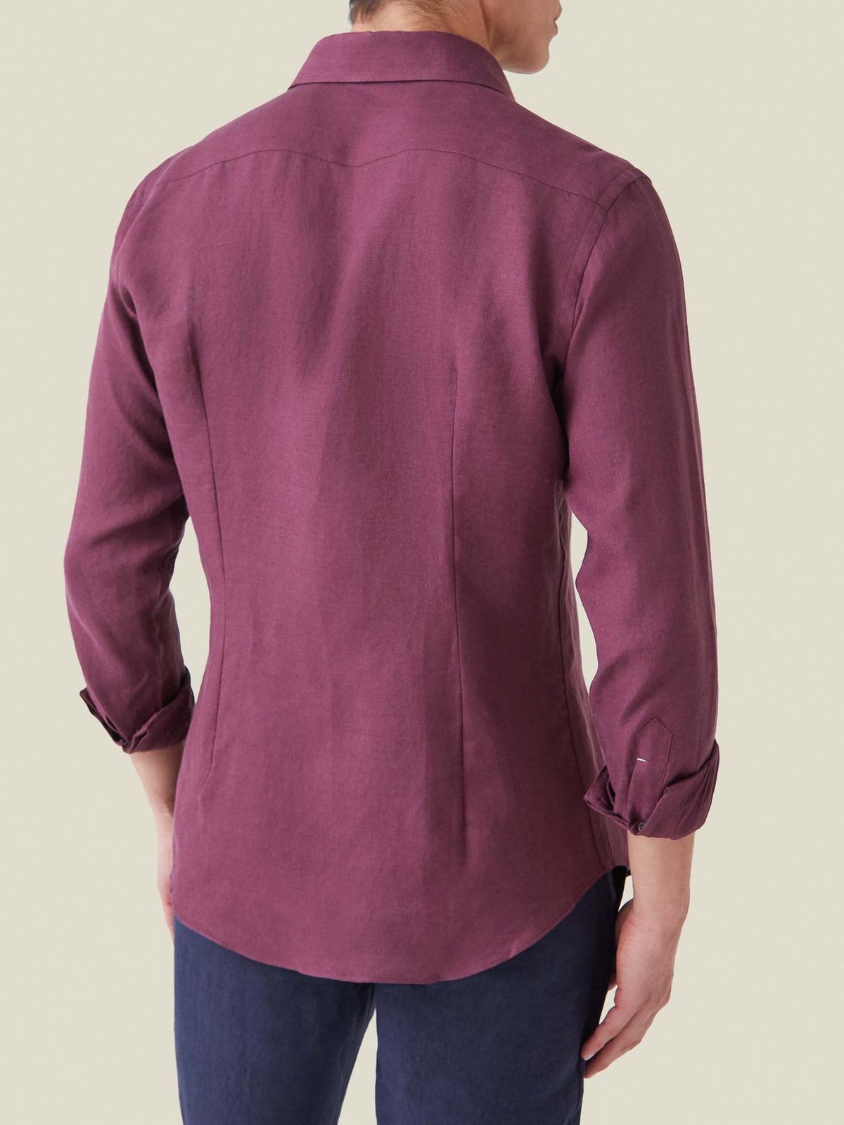 Back view of a model wearing the burgundy Portofino Linen Shirt, showing its tailored fit and rounded hem.