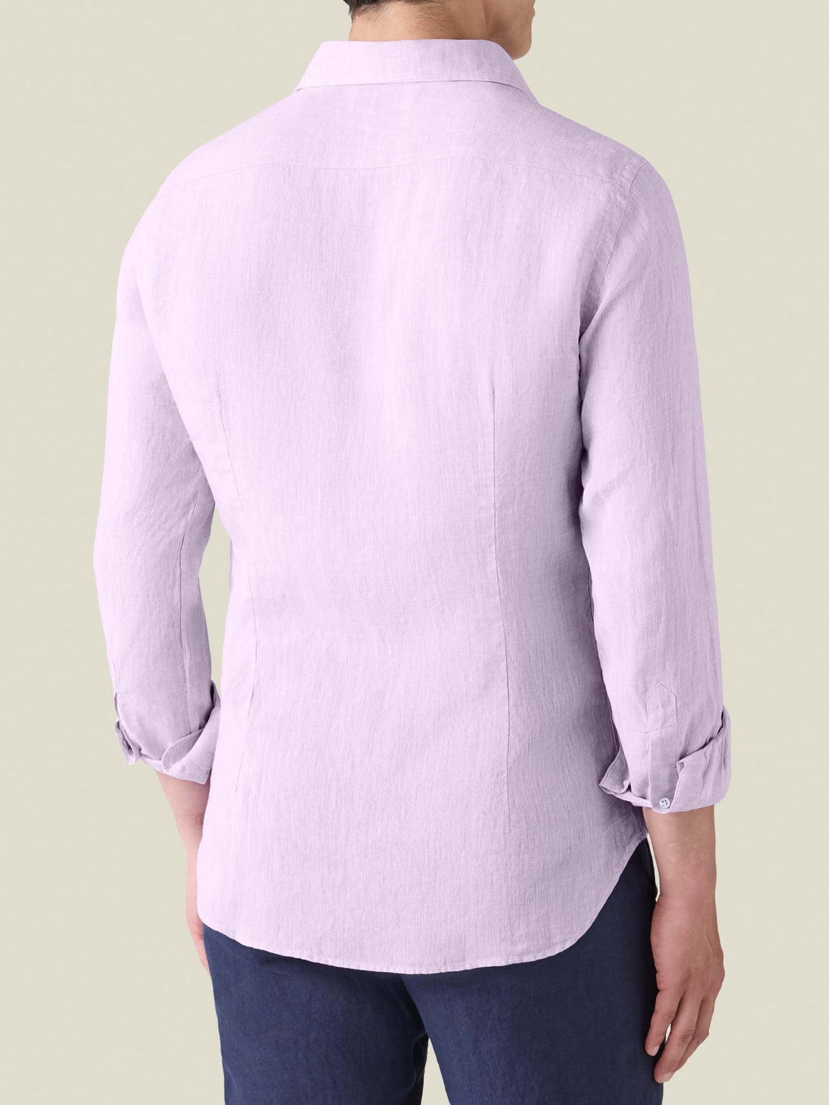 Back view of a model wearing the Portofino Linen Shirt in lilac, showcasing the tailored fit and rounded hem.